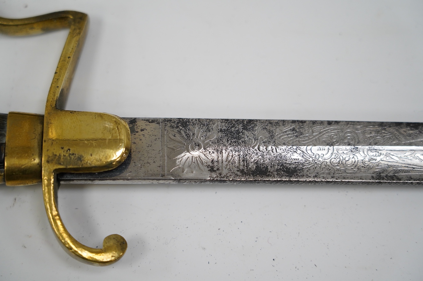 A Turkish WWI artillery sword, etched blade, Vanran Tagirian, Constantinople, brass stirrup hilt and horn grip, blade 70.5cm. Condition - fair, well worn